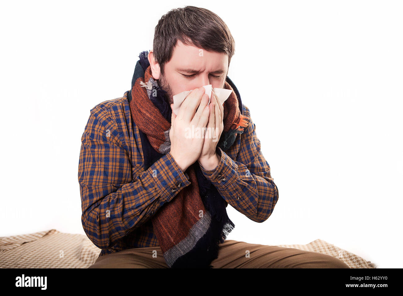 Ritratto di ragazzo indiano mal di gola, la mano sul collo della gola di compensazione. Uomo in piedi su sfondo semplice con ombra e copia dello spazio. Bel modello maschile. Foto Stock