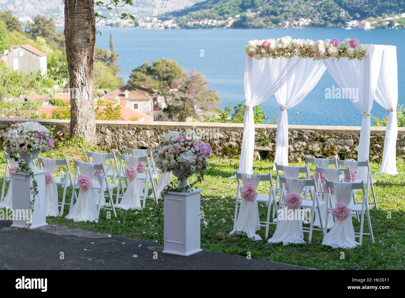 Arch per la cerimonia di nozze, decorato con un panno e fiori Foto Stock