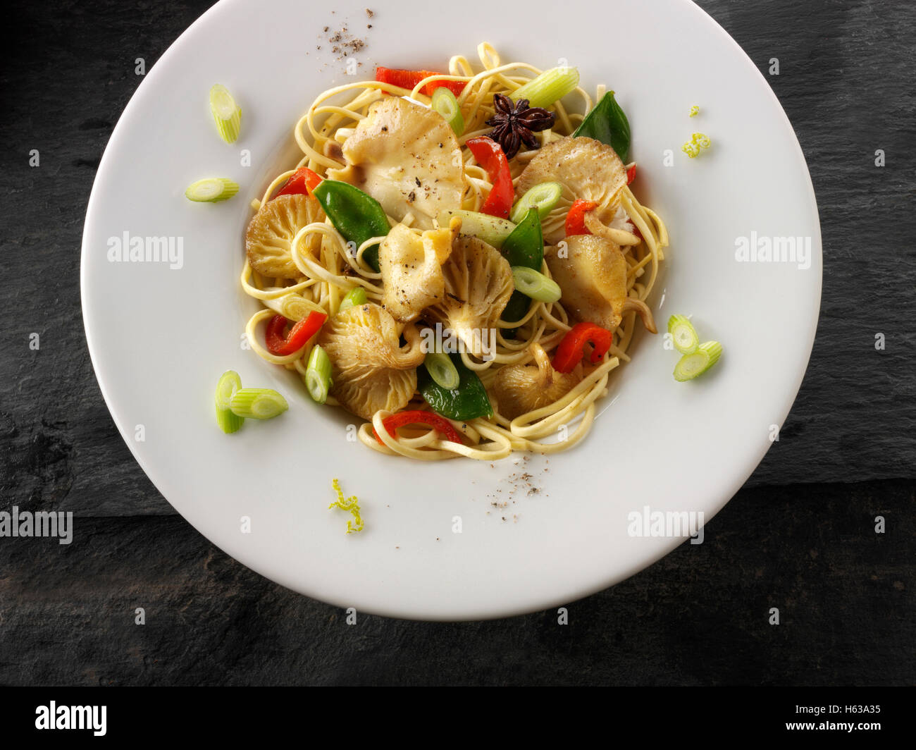 Giallo funghi Oyster stir fry con tagliatelle, gestire tout, pepe rosso, cipolline e avviare l'anice Foto Stock