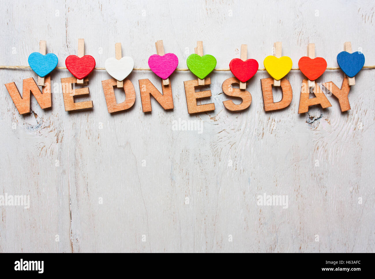Mercoledì parola da lettere di legno con clothespins colorati su un bianco sullo sfondo di legno Foto Stock