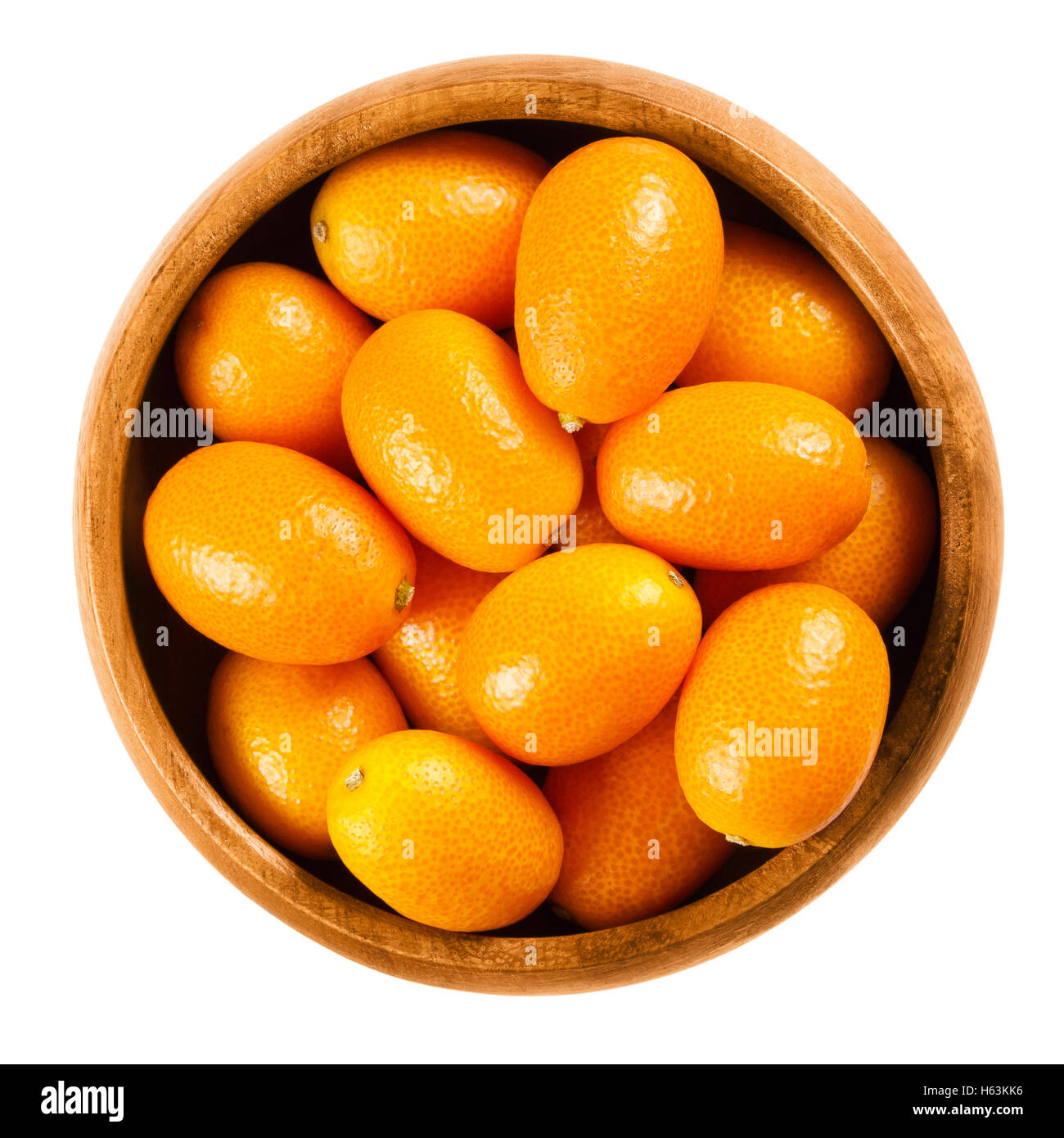 Kumquat fresca in una ciotola di legno su sfondo bianco, chiamato anche cumquats e Nagami kumquat. Commestibile ovale di piccoli frutti di colore arancione. Foto Stock