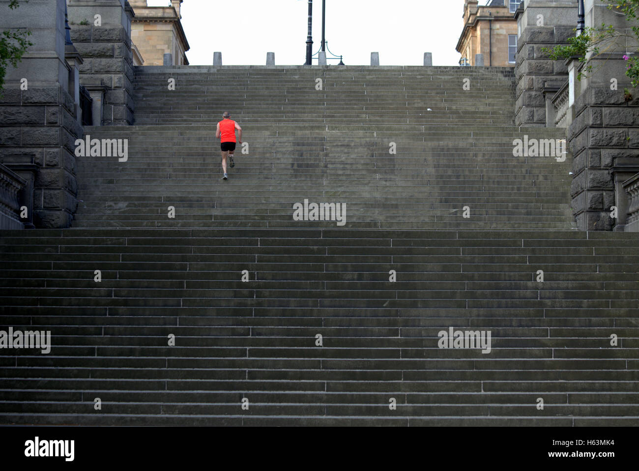 Runner maschio in esecuzione su per i gradini area del Park Circus di Glasgow Foto Stock