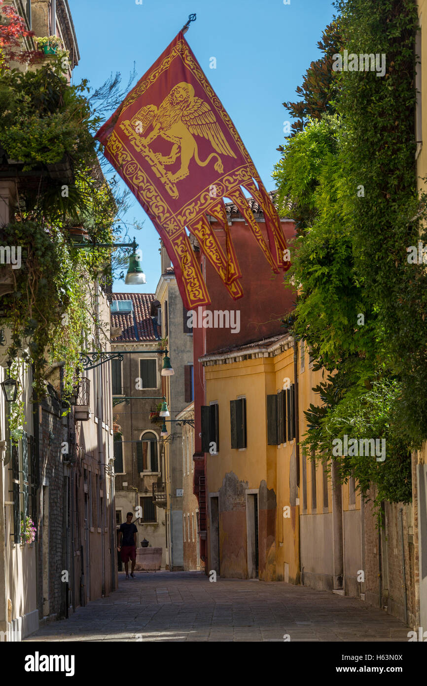 La bandiera di Venezia in una strada tranquilla a Venezia, Italia. La bandiera della regione italiana Veneto. Foto Stock