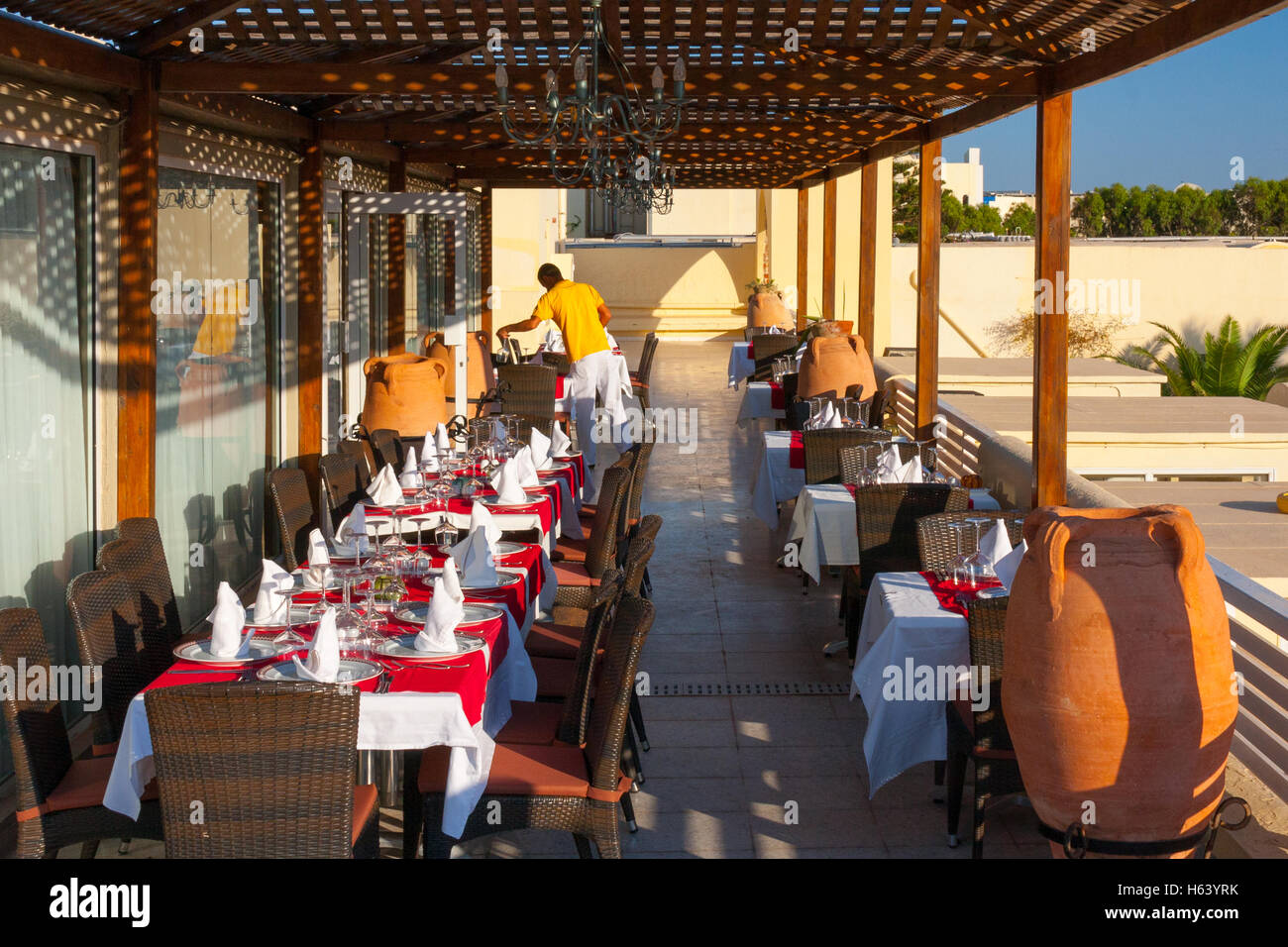 Cameriere posa di tabelle in un ristorante esterno veranda Foto Stock