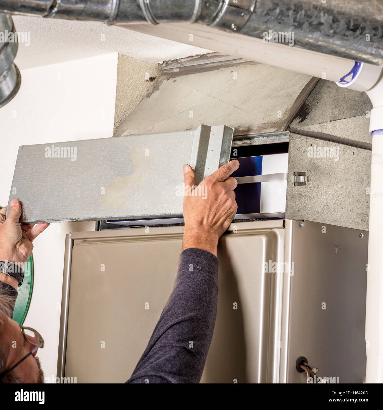 L'uomo rimuove il filtro del forno di coperchio per ispezione Foto Stock