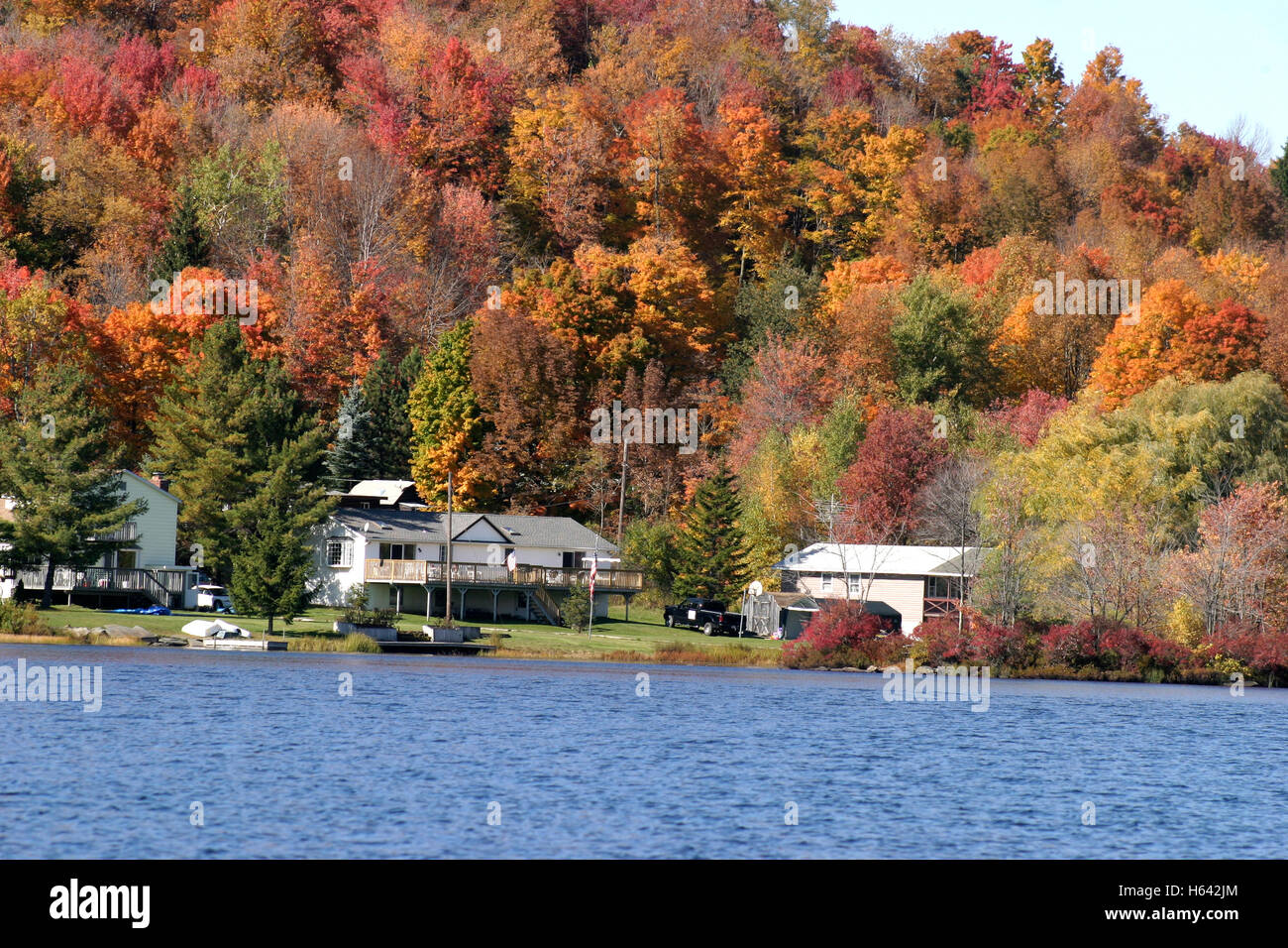 Case al lago di Upstate New York in autunno con alberi modifica dei colori Foto Stock