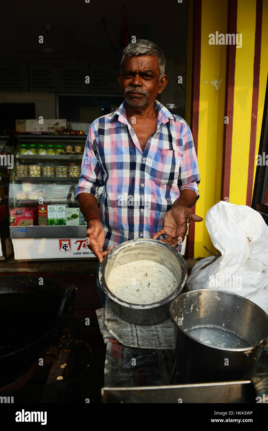 Un cuoco preparare Medu vada in un cibo di strada stallo in Tamil Nadu, India. Foto Stock