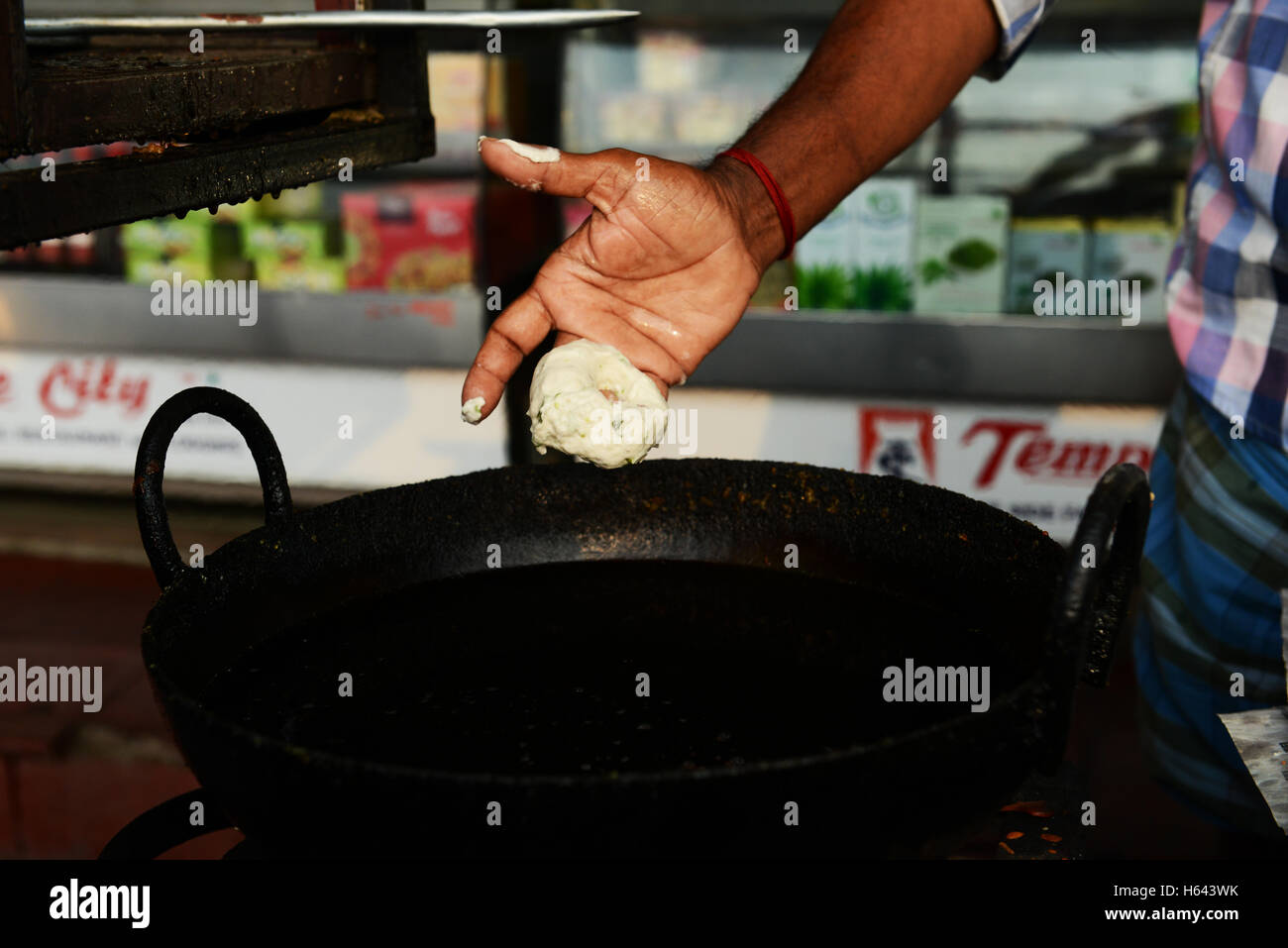 Un cuoco preparare Medu vada in un cibo di strada stallo in Tamil Nadu, India. Foto Stock