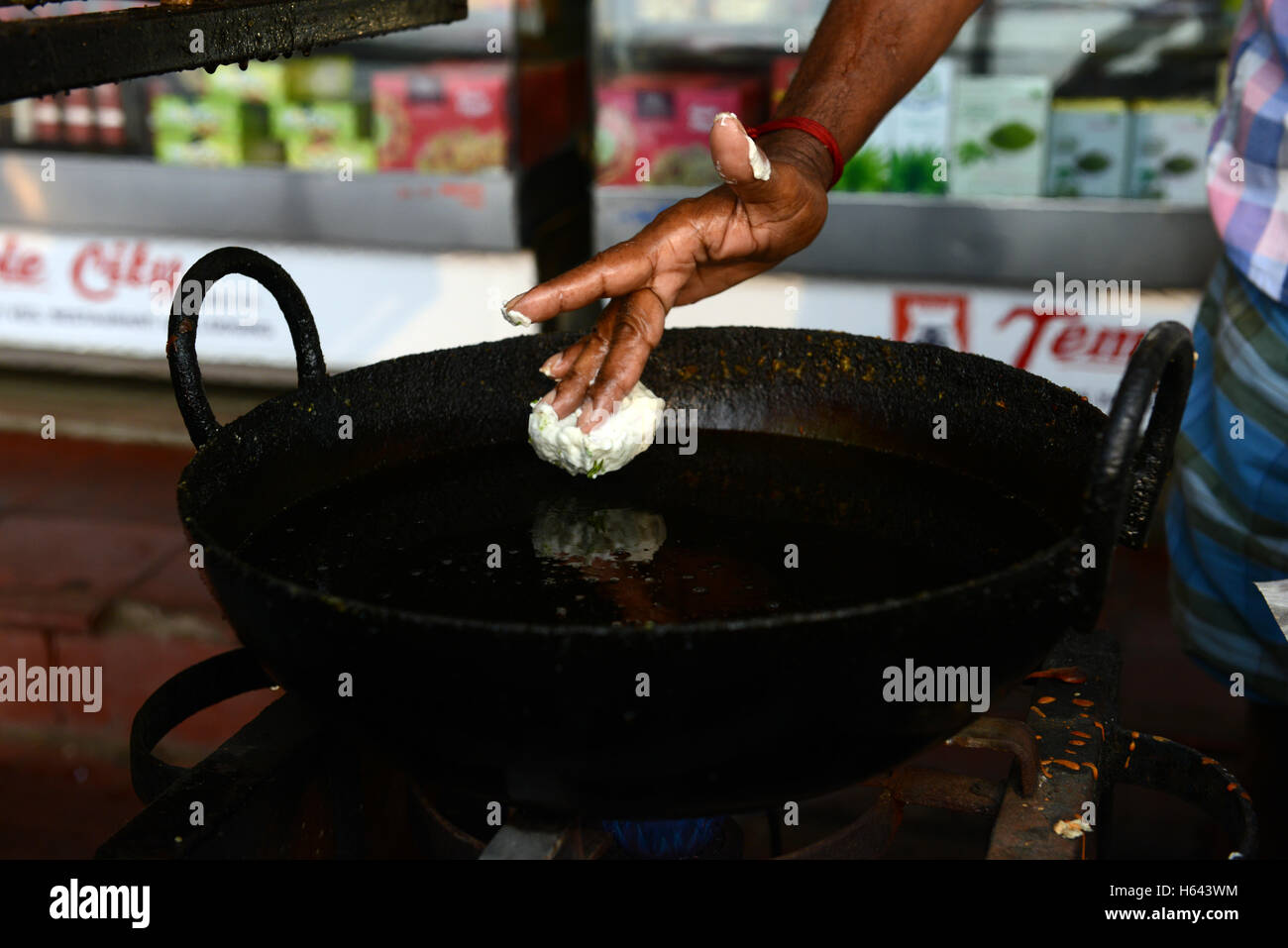 Un cuoco preparare Medu vada in un cibo di strada stallo in Tamil Nadu, India. Foto Stock