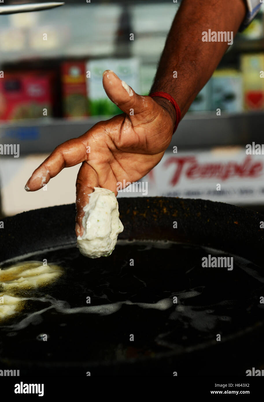 Un cuoco preparare Medu vada in un cibo di strada stallo in Tamil Nadu, India. Foto Stock