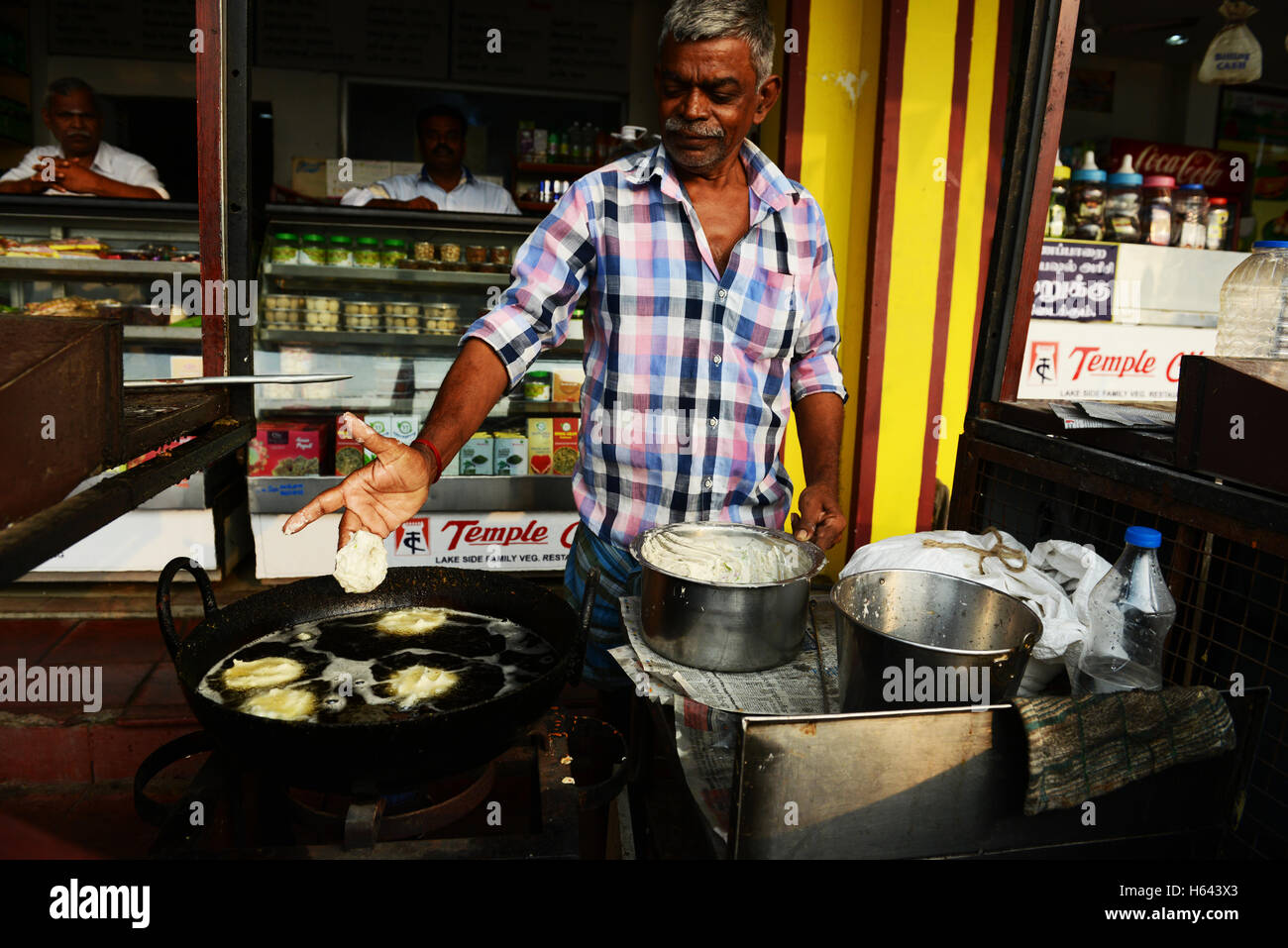 Un cuoco preparare Medu vada in un cibo di strada stallo in Tamil Nadu, India. Foto Stock