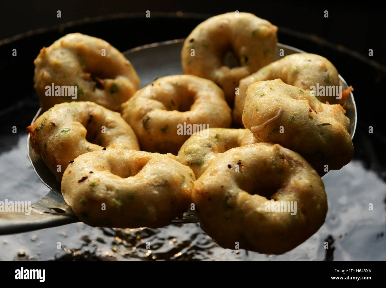 Un cuoco preparare Medu vada in un cibo di strada stallo in Tamil Nadu, India. Foto Stock