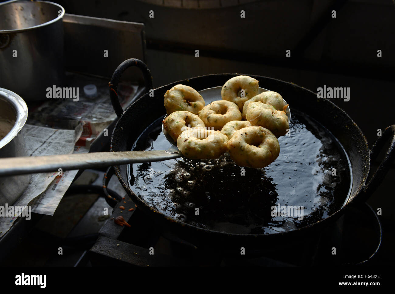 Un cuoco preparare Medu vada in un cibo di strada stallo in Tamil Nadu, India. Foto Stock