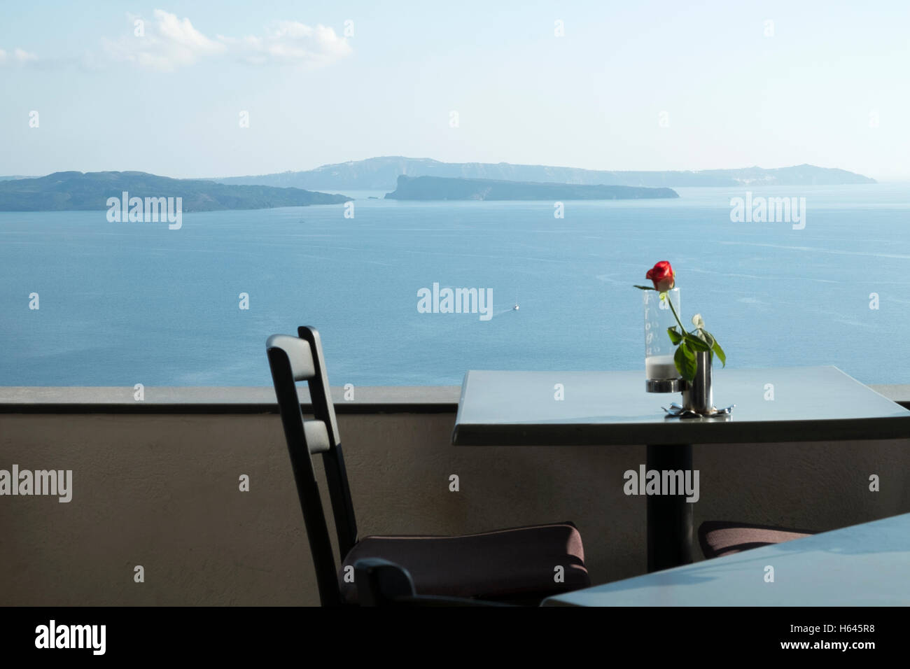 Un tavolo e sedia in un ristorante che si affaccia sulla caldera a Santorini, Grecia Foto Stock