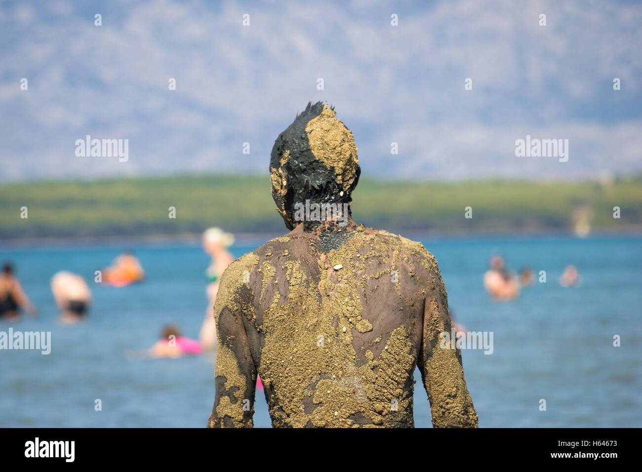 Persona non riconoscibile in sana fango sulla spiaggia torna portret view Foto Stock
