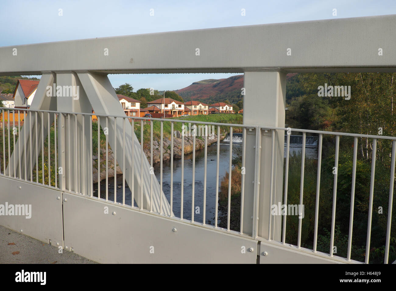 Aberfan Galles esecutivo moderno case lungo il fiume Taff visto attraverso una passerella pedonale Foto Stock