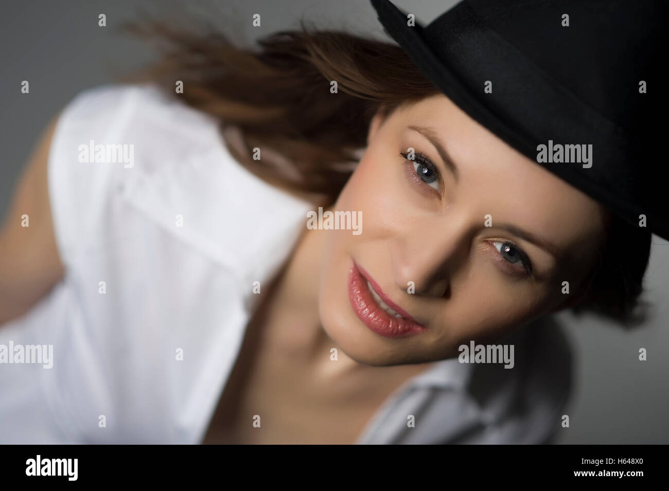 Donna che indossa un cappello e una camicia bianca Foto Stock