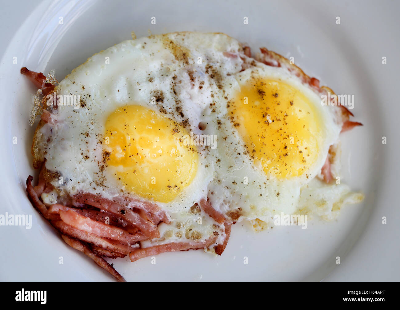 Uova strapazzate su una piastra con salsiccia fotografato in close-up Foto Stock