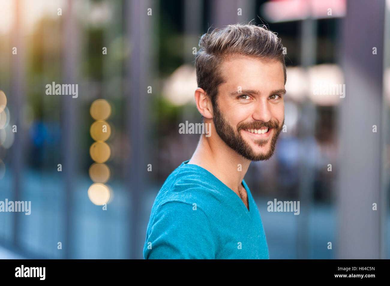 Ritratto di giovane sorridente uomo in città Foto Stock