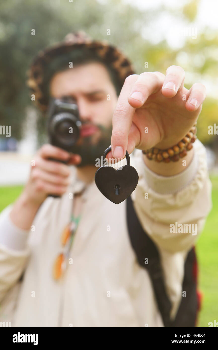 Uomo di cuore di registrazione a forma di serratura di amore nella sua mano con vintage telecamera video Foto Stock