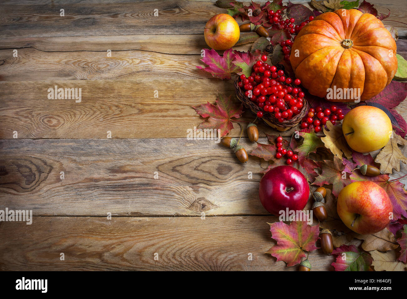Il messaggio di saluto di ringraziamento con sfondo arancione zucche, mele e foglie di autunno. Sfondo di ringraziamento con verdure di stagione Foto Stock