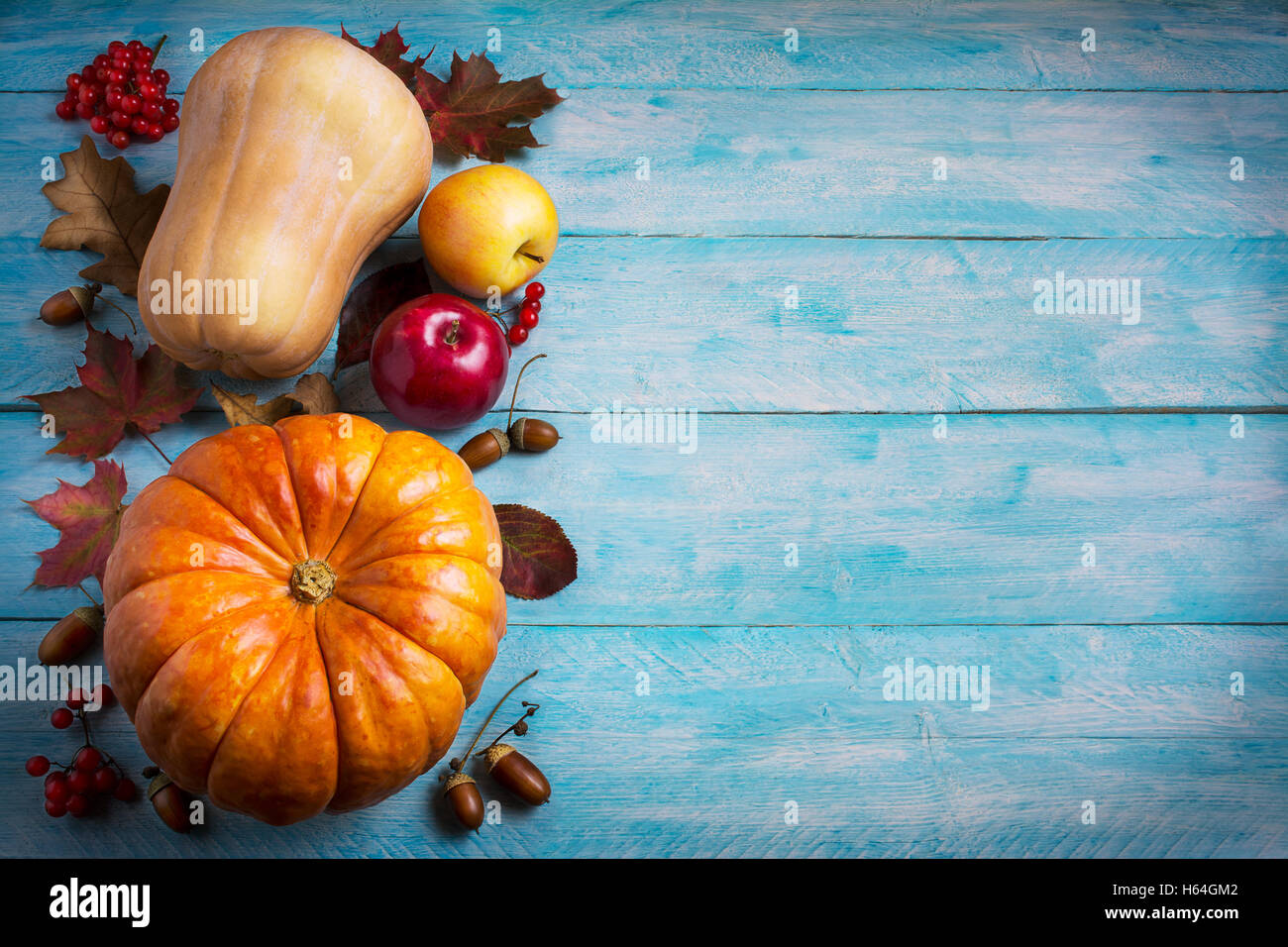 Il messaggio di saluto di ringraziamento con orange zucche e caduta foglie su sfondo blu. Sfondo di ringraziamento con verdure di stagione Foto Stock