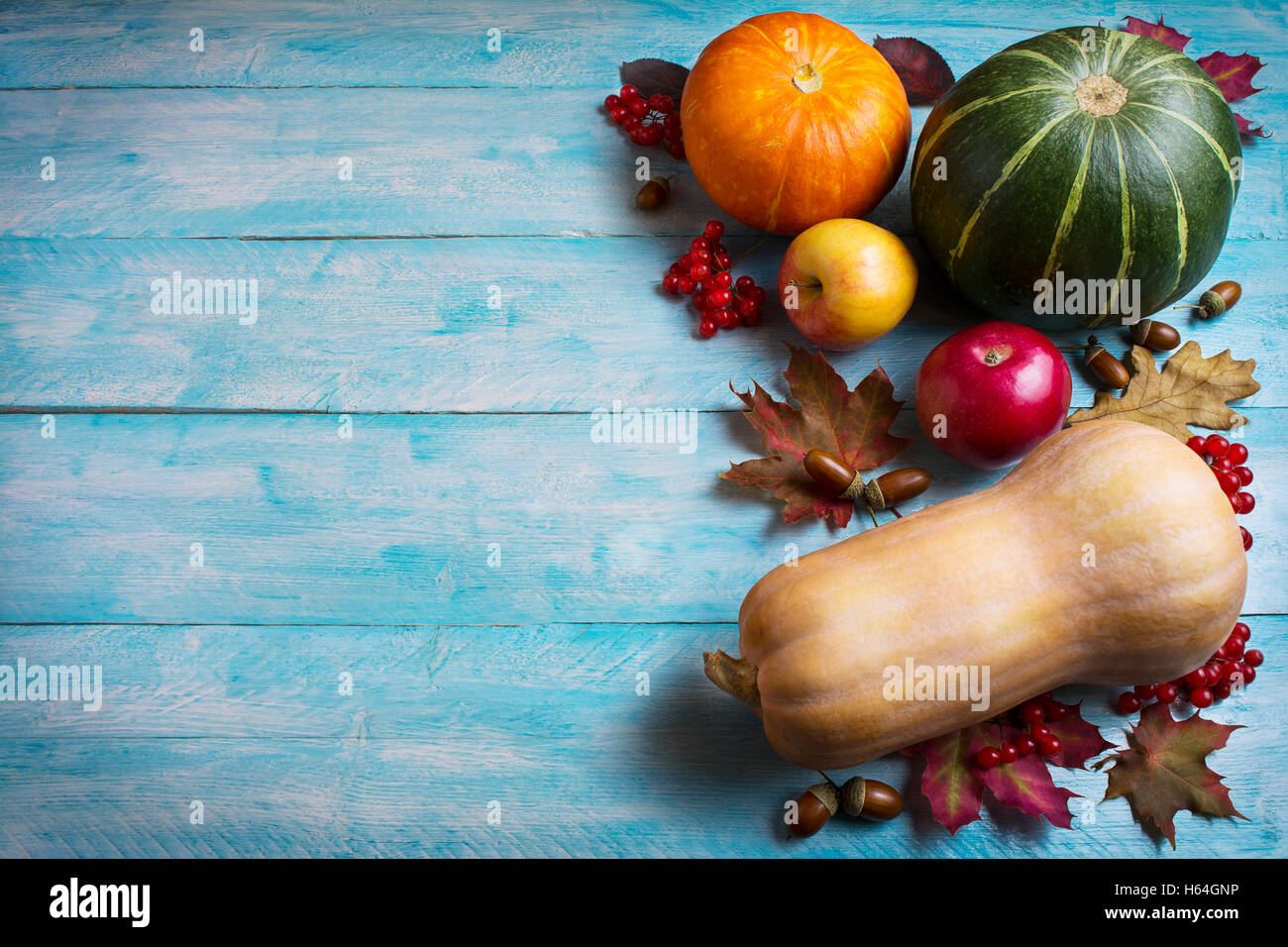 Il messaggio di saluto di ringraziamento con zucche e mele su blu sullo sfondo di legno. Sfondo di ringraziamento con verdure di stagione e Foto Stock