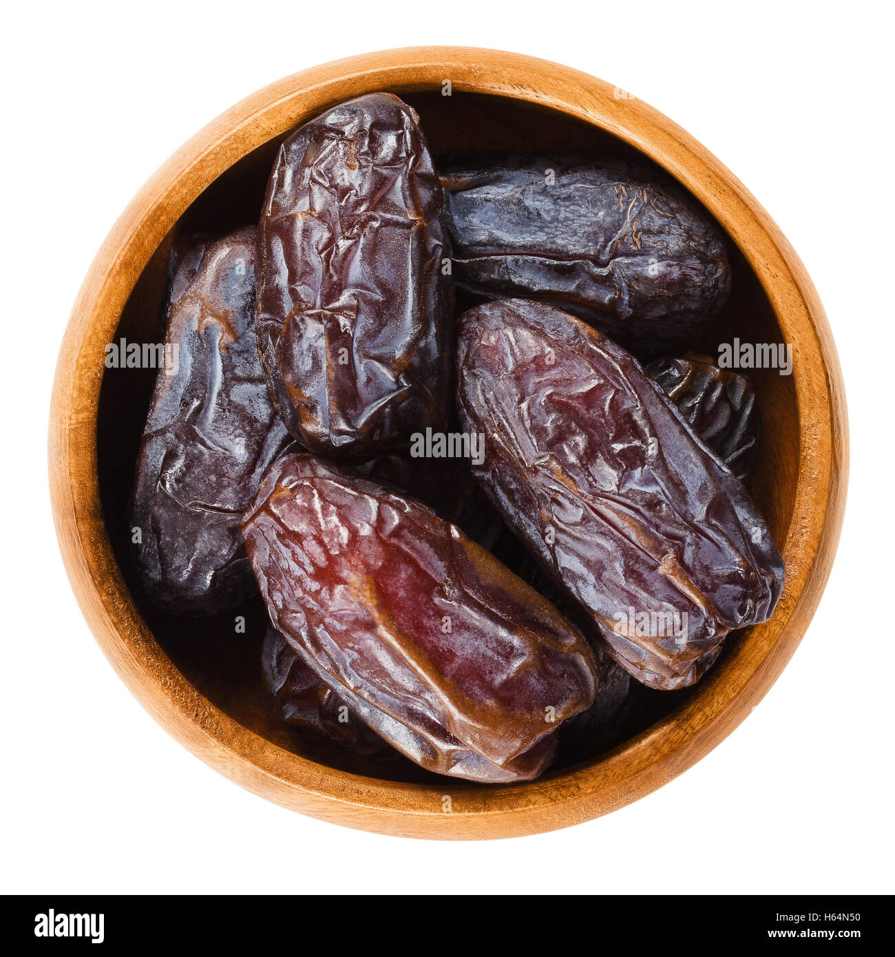 Essiccato Medjool date dal Marocco in una ciotola di legno su sfondo bianco, chiamato anche Mejhool. Grande, dolce e succulenti frutti. Foto Stock