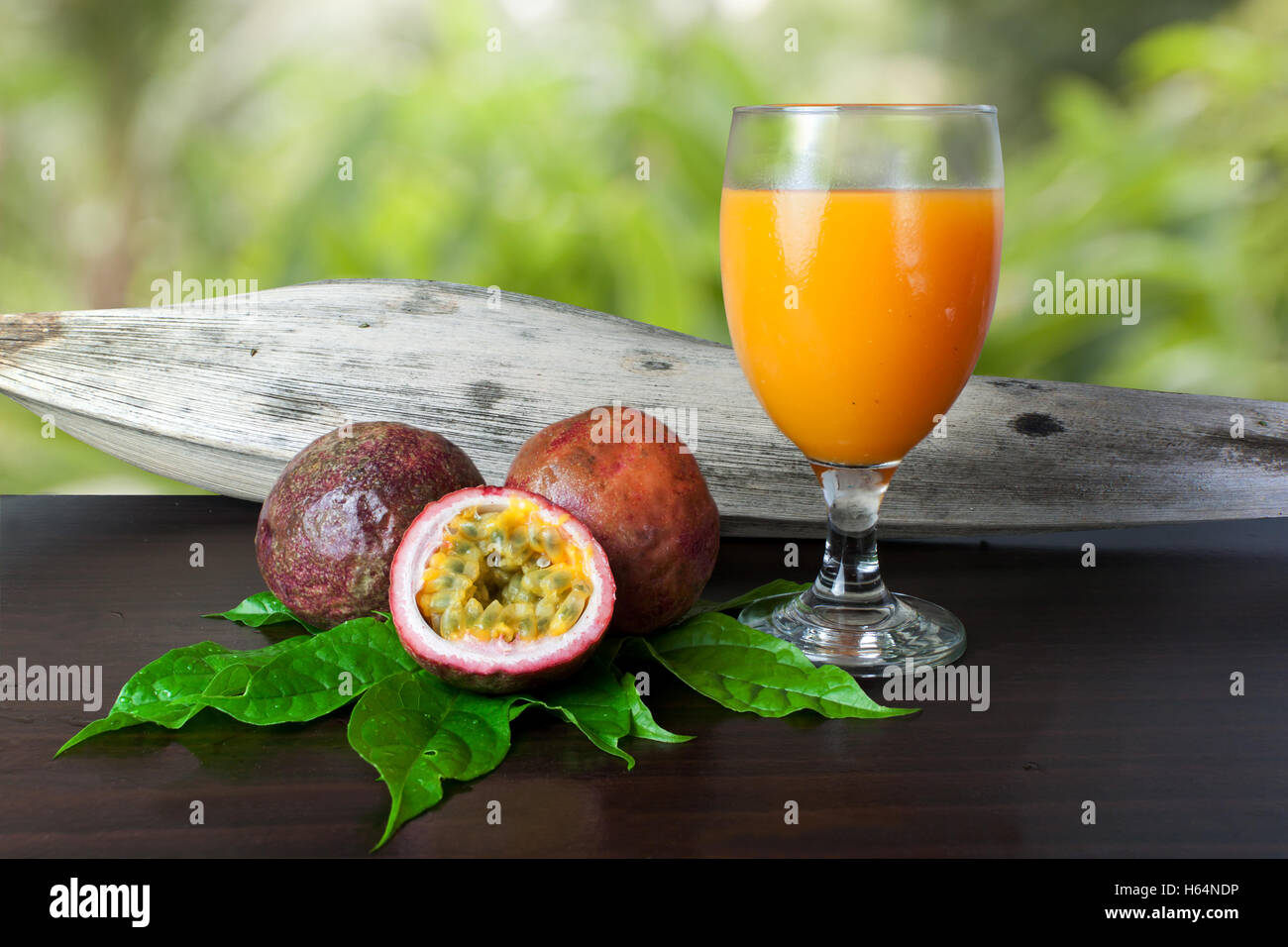 Il frutto della passione fresco e succo di frutto della passione sulla tavola di legno Foto Stock