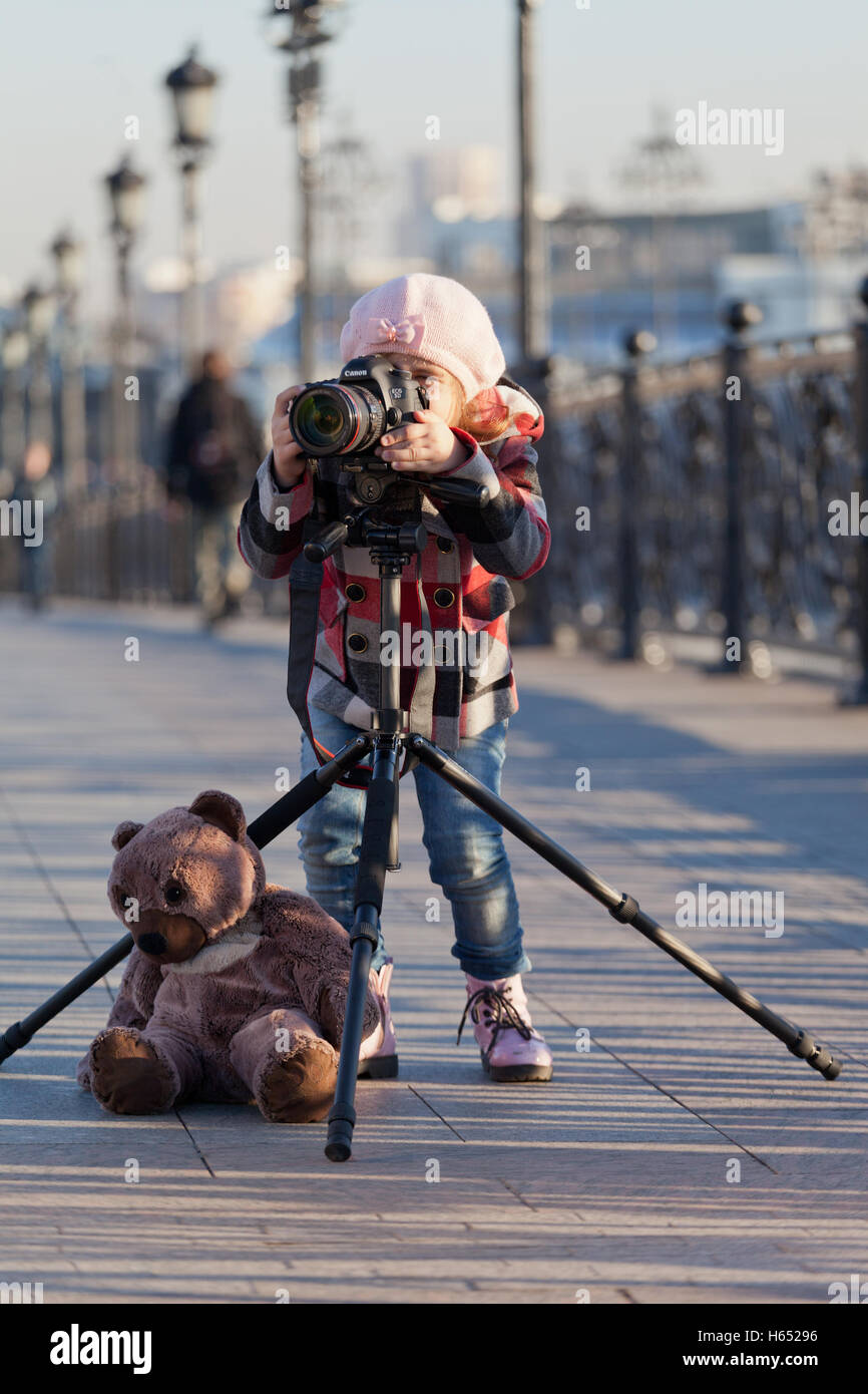 Bambina con la telecamera su un supporto di fotografie sulla strada Foto Stock