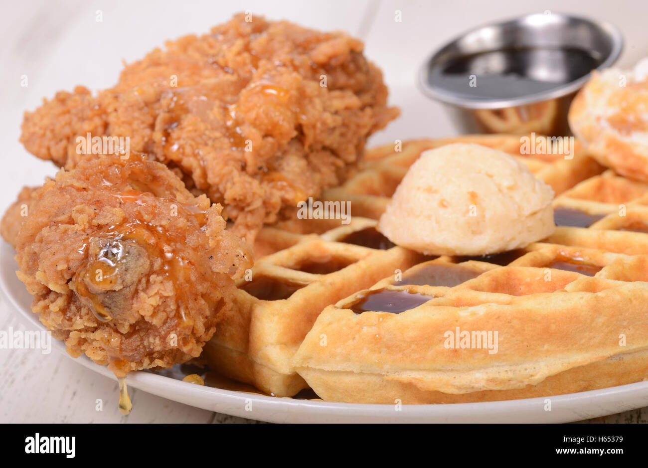Il pollo e le cialde servite con lo sciroppo di acero, e miele di arancio burro Foto Stock