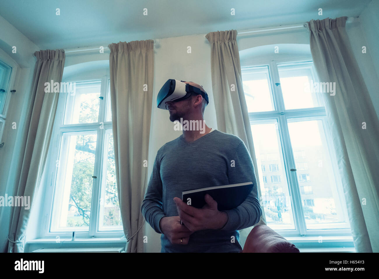 Agente immobiliare di casa indossando la realtà virtuale (VR) gli occhiali di protezione Foto Stock