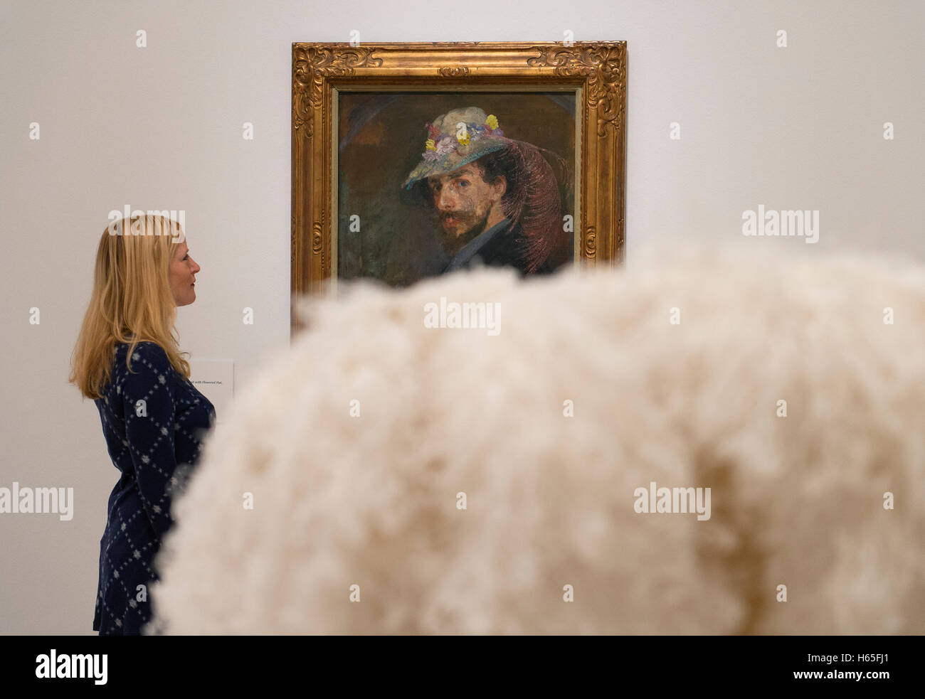 Royal Academy di Londra, Regno Unito. 25 ottobre, 2016. La prima grande mostra di belga artista modernista di James Ensor (1860-1949) il lavoro che si terrà nel Regno Unito in venti anni, dal 29 ottobre 2016 al 29 gennaio 2017. Foto: Autoritratto con cappello fiorito, 1883. Olio su tela. Mu.ZEE, Oostende. Posti con un membro del personale della Gallery e visualizzati su un di piume di struzzo copricapo da Karl Kersten. Credito: artsimages/Alamy Live News. Foto Stock