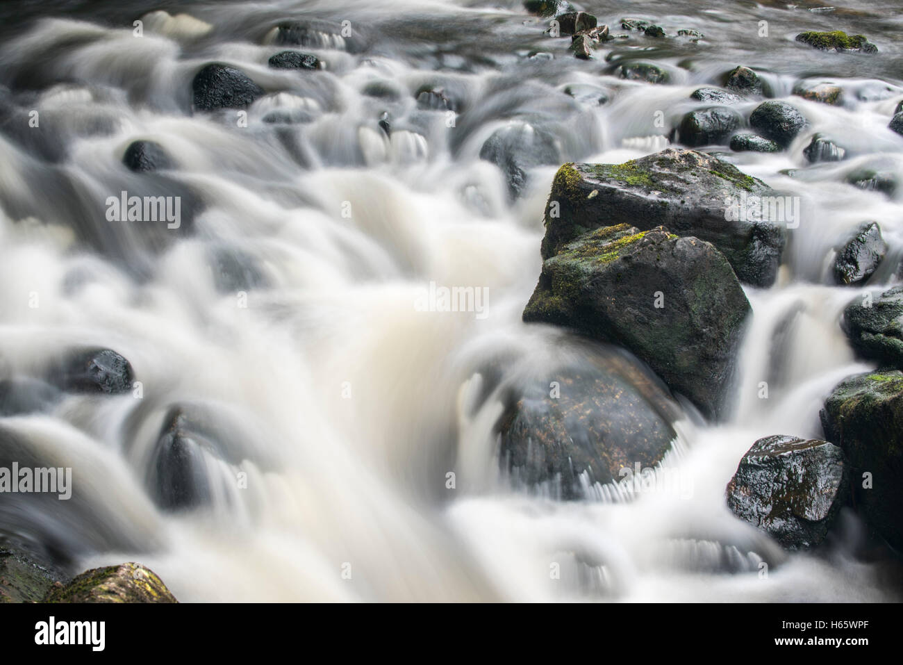 Dettaglio di acqua che scorre su grossi massi nel fiume Garry in Glengarry foresta, Lochaber, Highlands scozzesi, Scozia Foto Stock