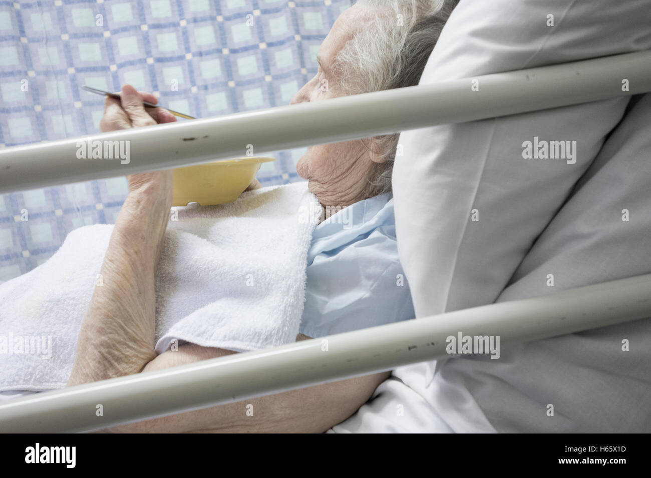 Novanta anni paziente femmina di mangiare nel letto nella nazione Servizio Sanitario ospedale in Inghilterra, Regno Unito. Foto Stock