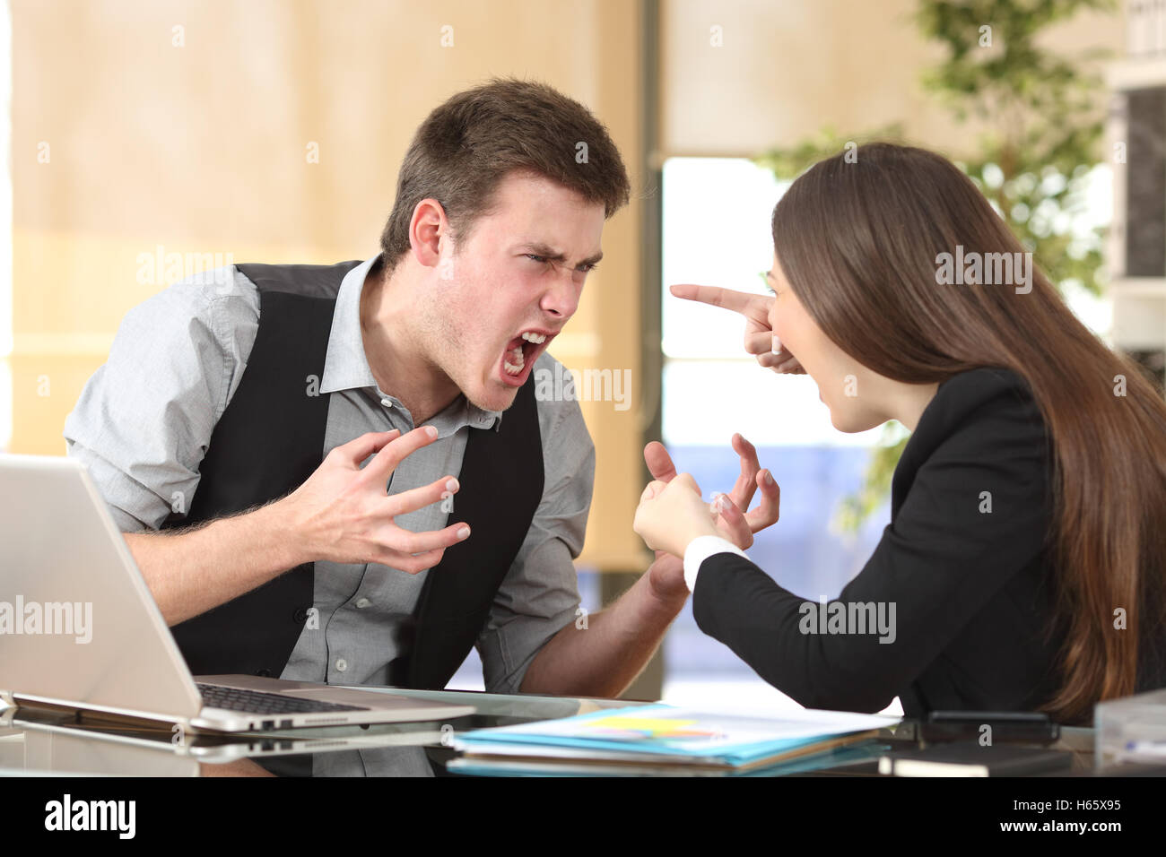 Due imprenditori furioso sostenendo fortemente in un PC desktop con un background di office Foto Stock