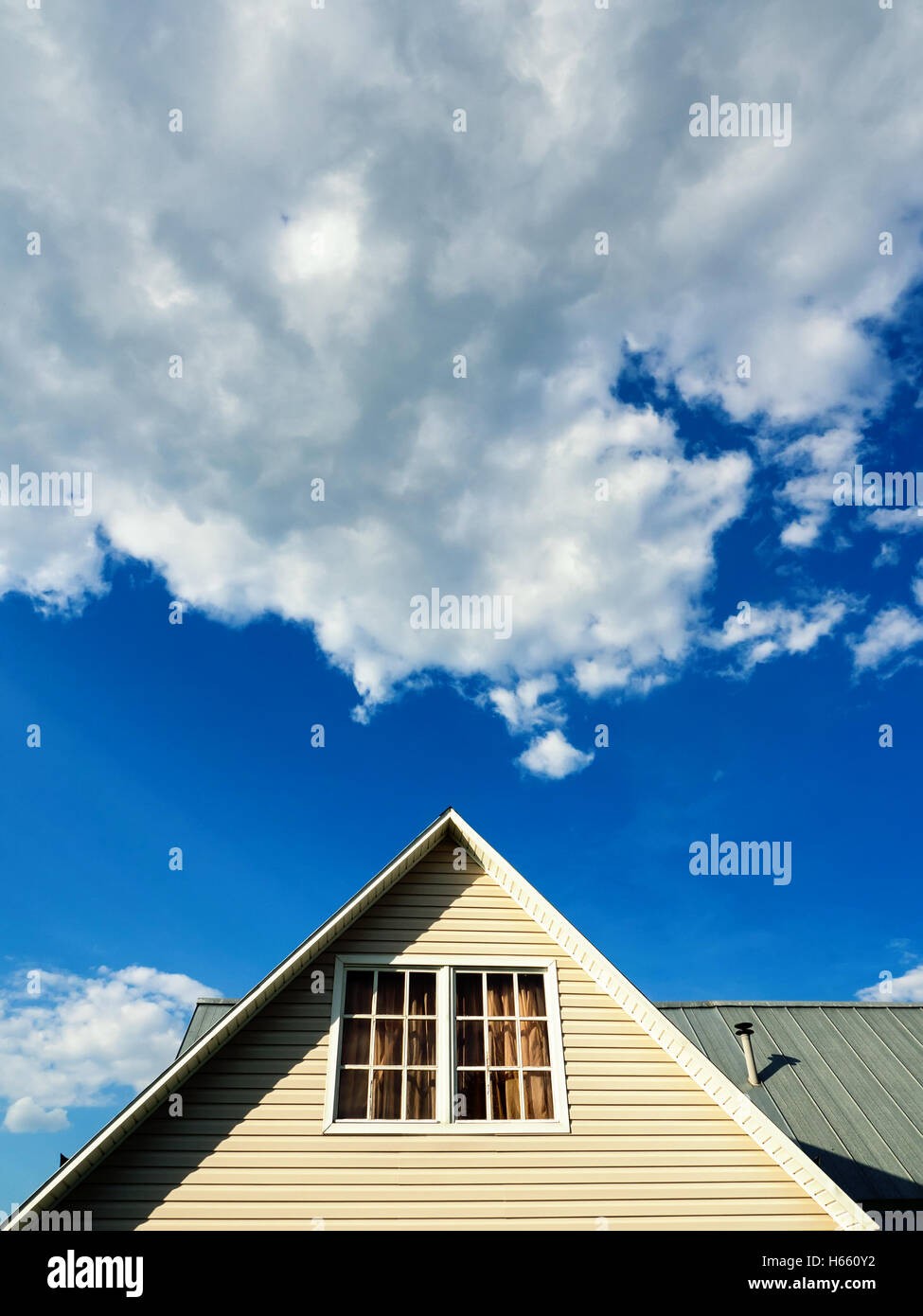 Una casa di campagna tetto contro il cielo blu e il cloud computing Foto Stock