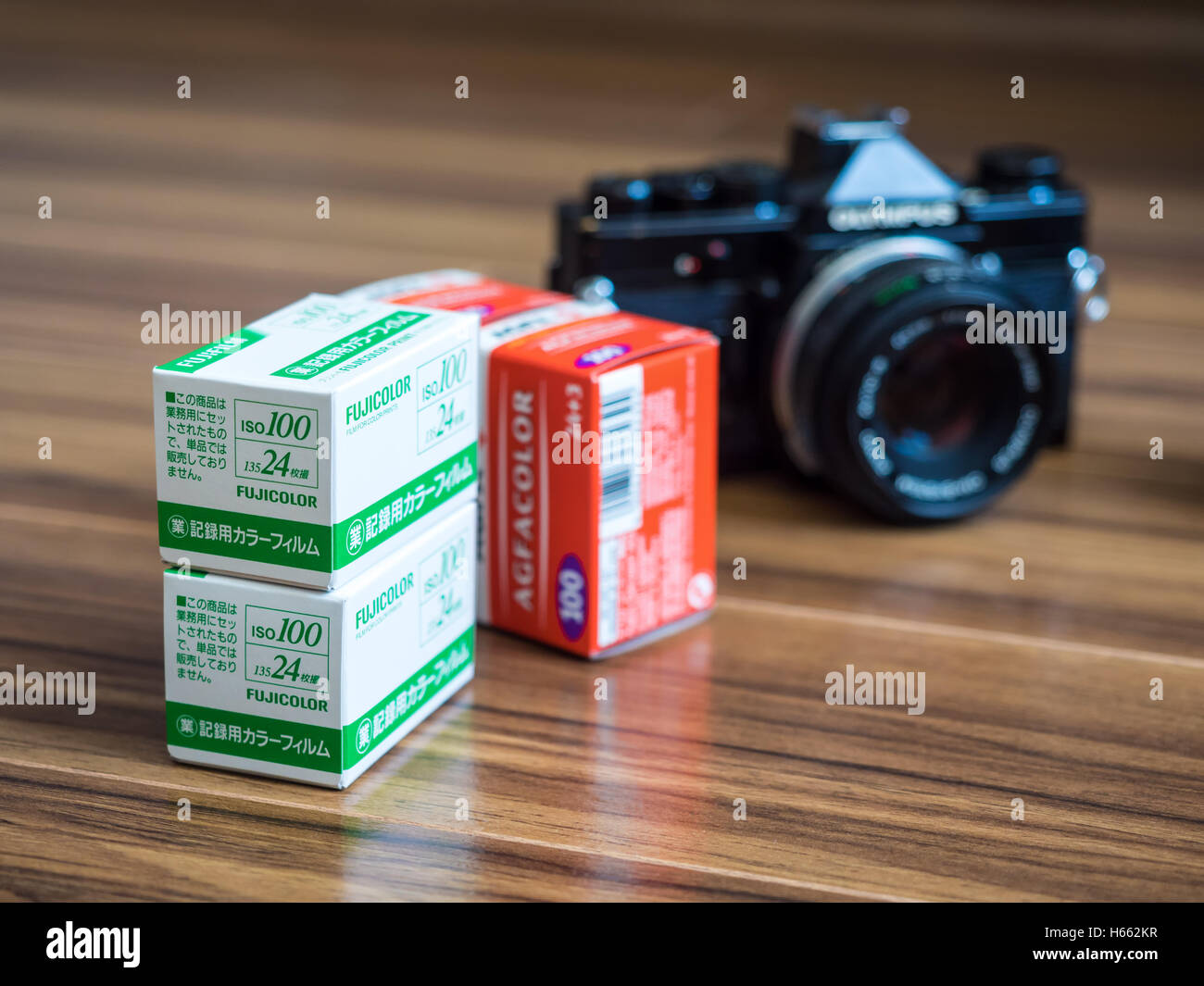 Fotografia analogica. Fujicolor e Agfacolor 35mm rotoli di pellicola e la vecchia Olympus SLR fotocamera a pellicola. Foto Stock