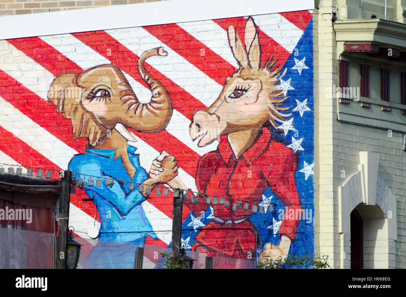 Carta murale raffigura Democrat asino e elefante repubblicano come donne stringendo le mani. Foto Stock