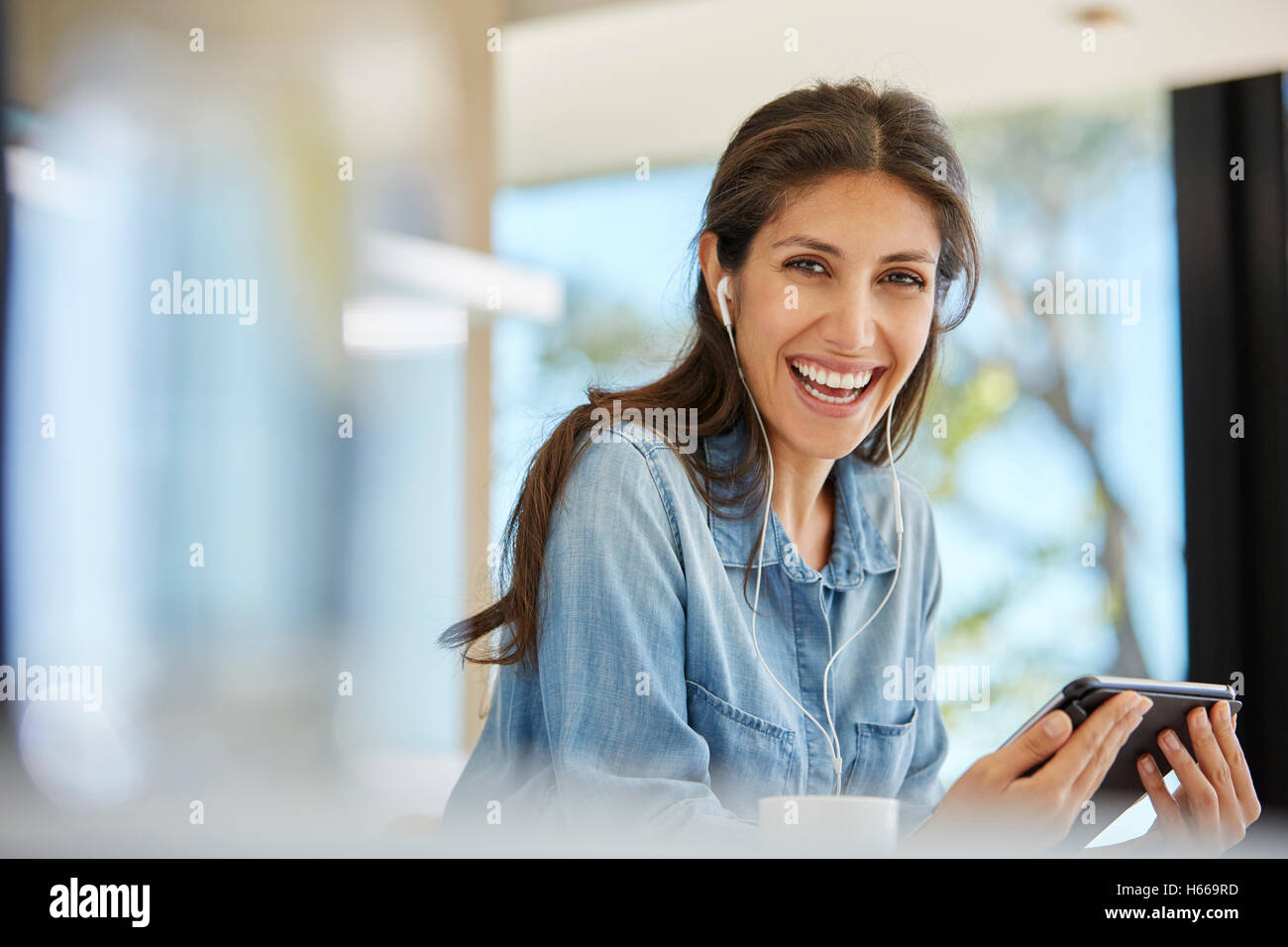 Ritratto di donna entusiasta con tavoletta digitale e cuffie Foto Stock