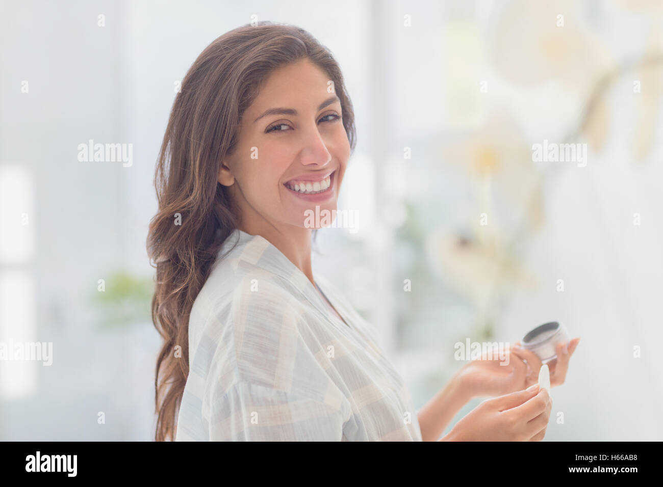 Ritratto sorridente brunette donna applicare trucco Foto Stock