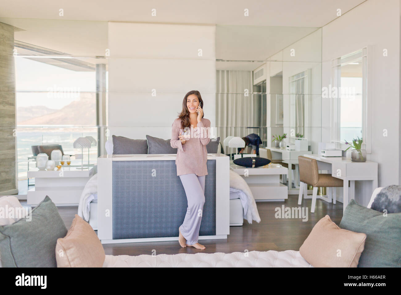 Donna che parla al cellulare nel lusso moderno home vetrina camera da letto Foto Stock