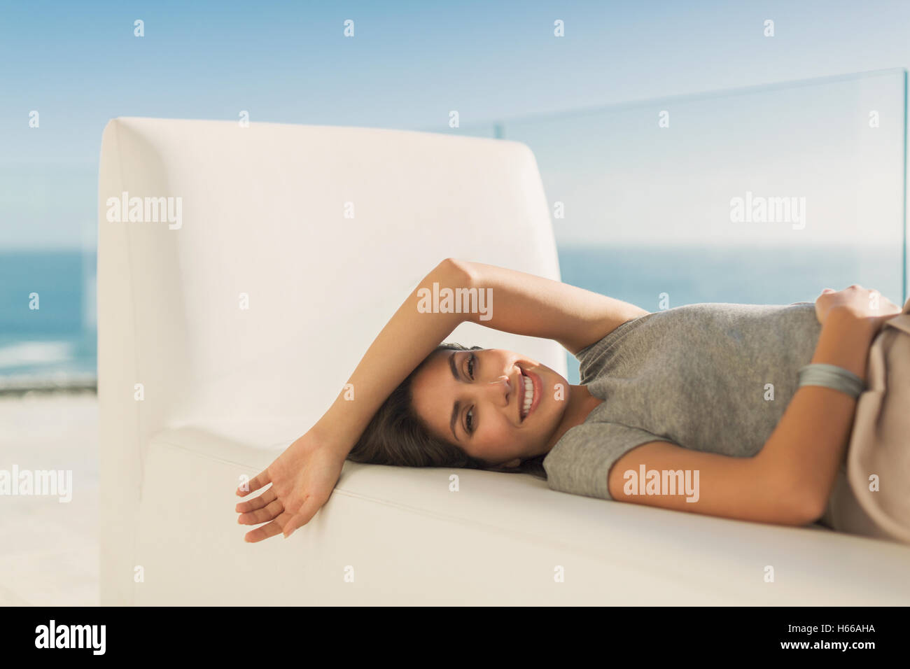 Ritratto di donna sorridente posa rilassante sulla chaise lounge Foto Stock