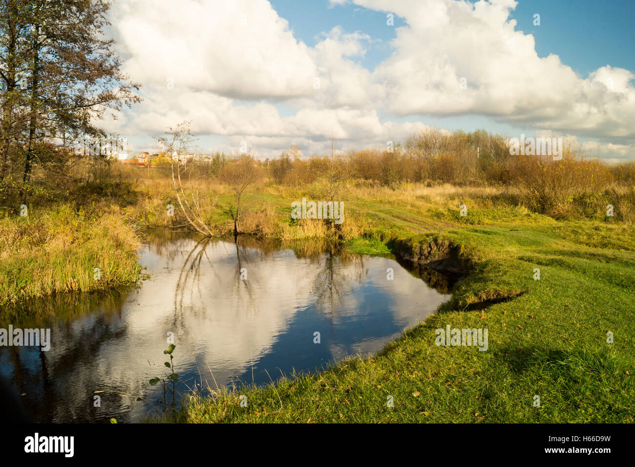 Paesaggio autunnale con piccolo fiume su sfondo blu cielo Foto Stock