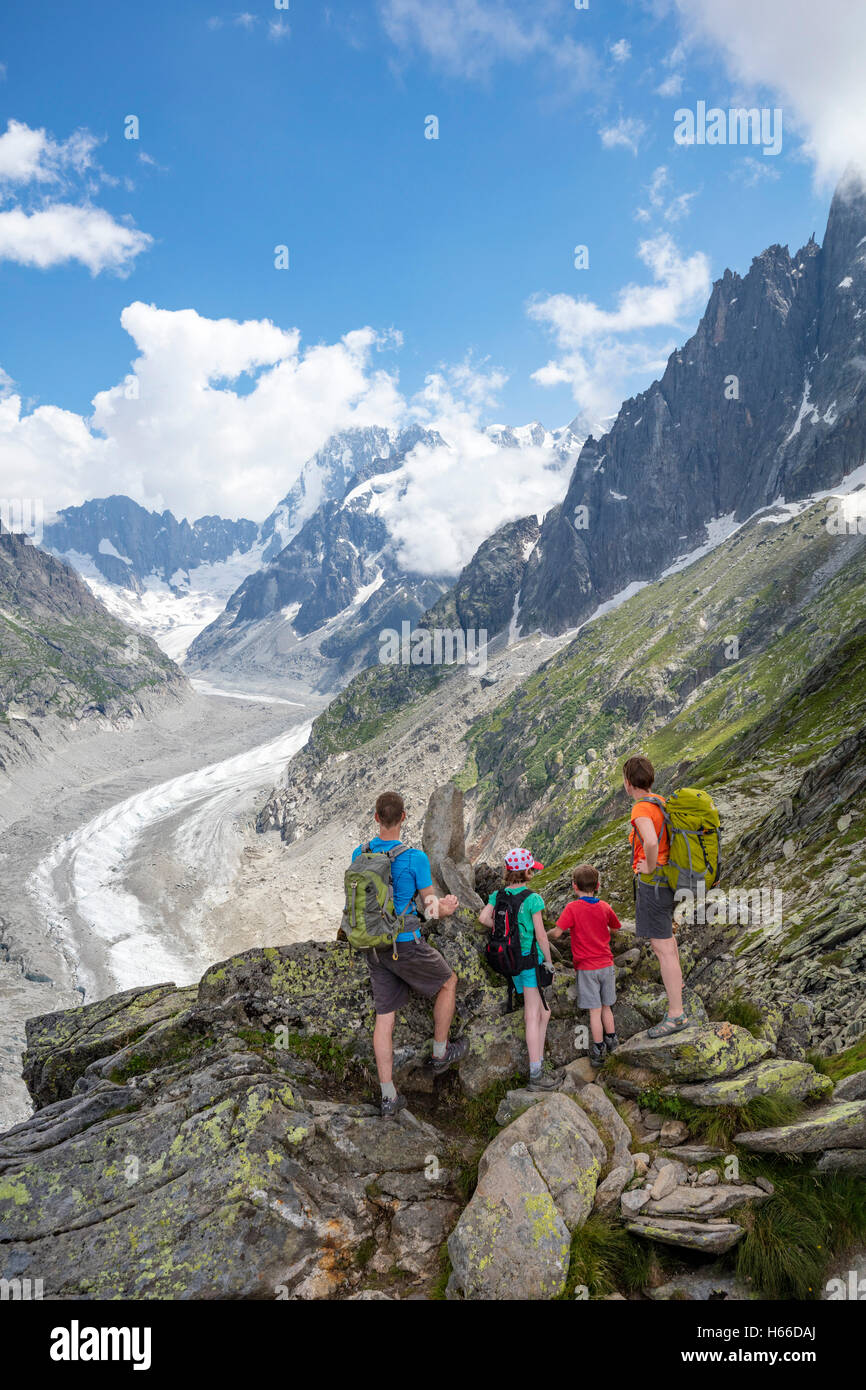 Escursionismo famiglia guardando attraverso Mer de Glace glacier dal segnale Forbes, Montenvers. Valle di Chamonix, sulle Alpi francesi, Francia. Foto Stock