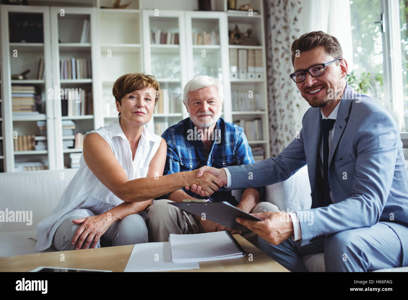 Advisor finanziario stringono le mani con i senior donna Foto Stock