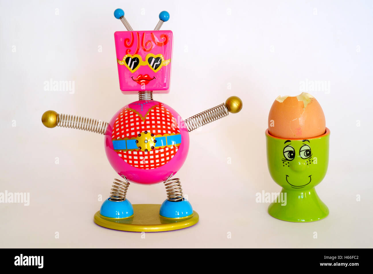 Luminose colorate timer con uova sode o in una faccina sorridente eggcup Foto Stock