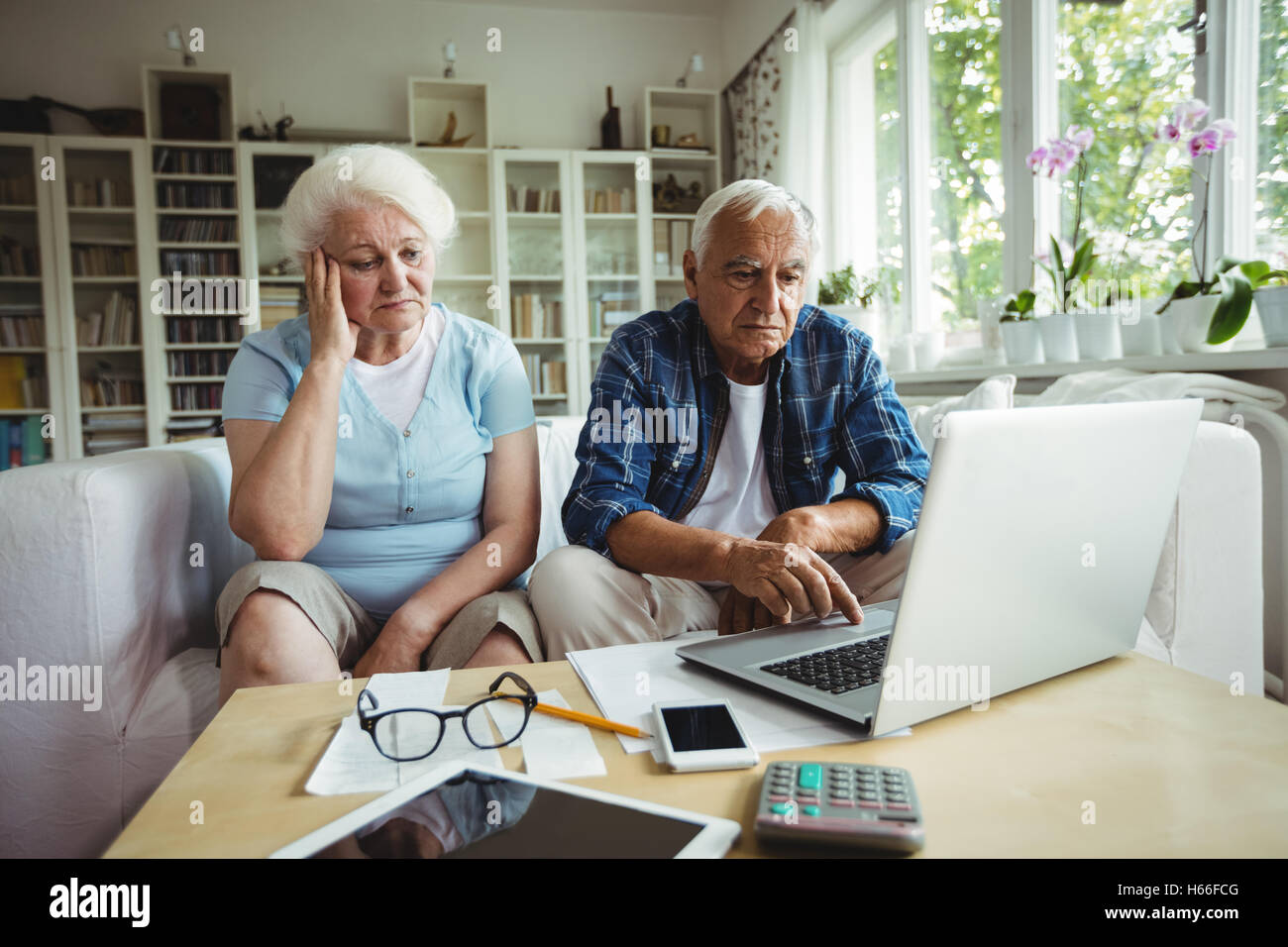 Preoccupato coppia senior utilizzando laptop Foto Stock
