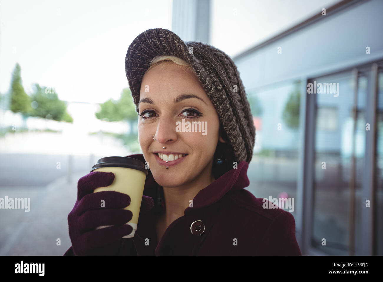 Donna sorridente e tenendo una tazza di caffè Foto Stock