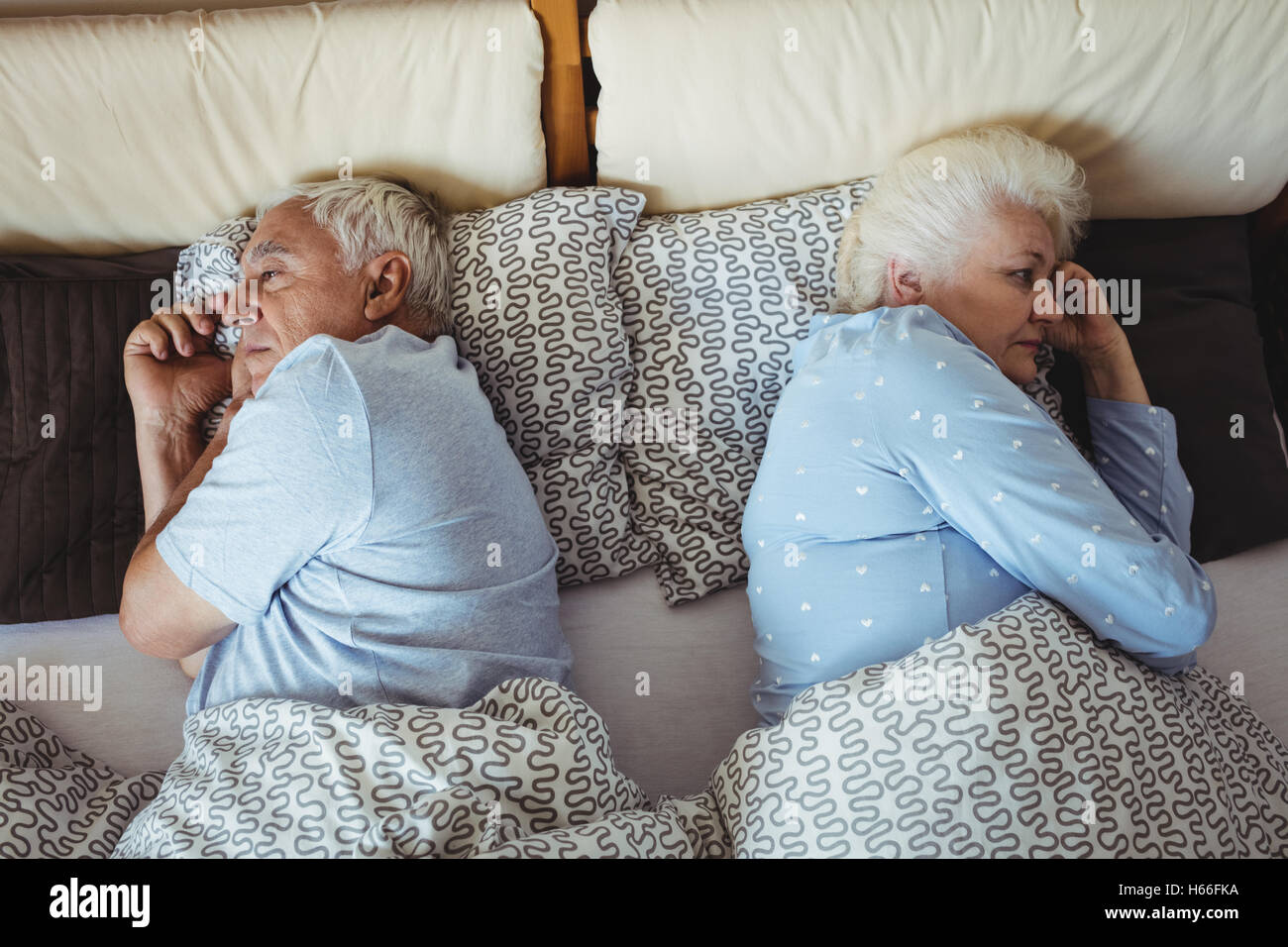 Sconvolto coppia senior rilassante sul letto Foto Stock